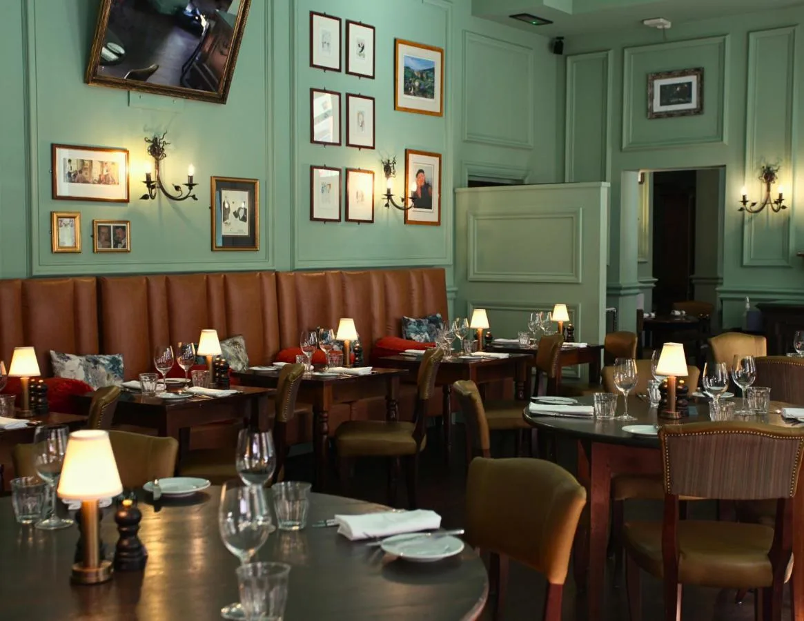 a dining room with tables and chairs with lights at Hotel du Vin Birmingham in Birmingham