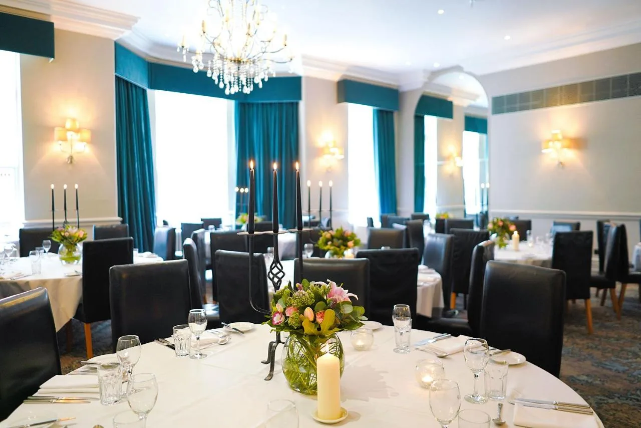 a conference room with tables and chairs and a chandelier at Hotel du Vin Birmingham in Birmingham